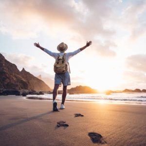istockphoto-1285301614-612×612 Young man arms outstretched by the sea at sunrise enjoying freedom and life, people travel wellbeing concept